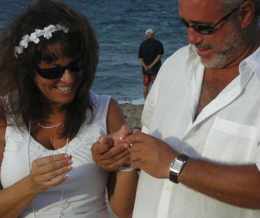 Couple exchanges rings on the beach